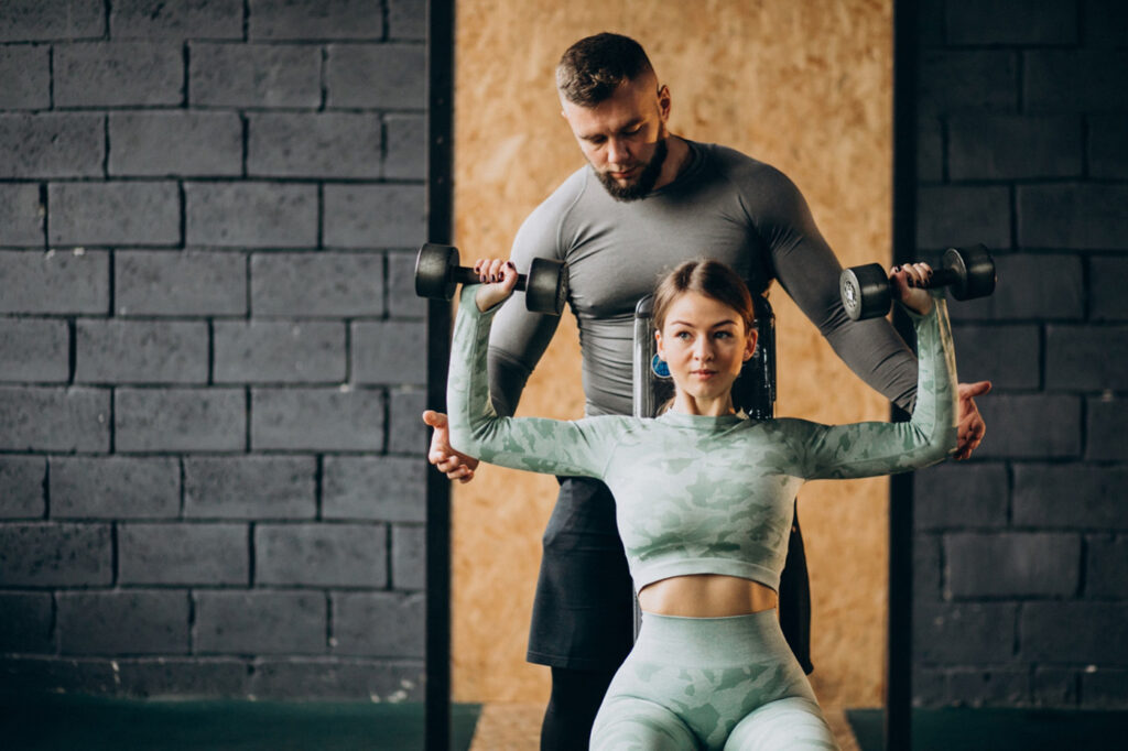 woman-doing-workout-gym-with-trainer